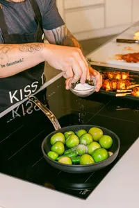 Jet Tila seasoning a pan of tomatillos on a Bosch induction cooktop
