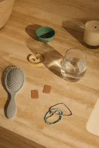 Overhead vanity flat lay with a hairbrush, water glass, and everyday personal items