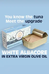 Natural Catch White Albacore in extra virgin olive oil ad, "You know the tuna. Meet the upgrade.", with the box and open tin on light blue