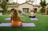 Yoga instructor leading a class on the lawn at The Woodlands, Estancia La Jolla hospitality campaign
