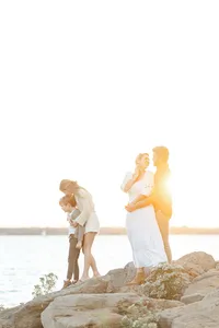 A beautiful family sunset photo as they are posing on rocks at a local DFW lake for their photographer.