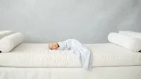 Sleeping newborn baby wrapped in soft fabric during a Dallas newborn photography session