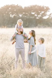 A Frisco Tx Family posing in the middle of a field for family photos.