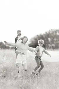 Black and white photo of 2 children running in an open field at a Fort Worth TX park.