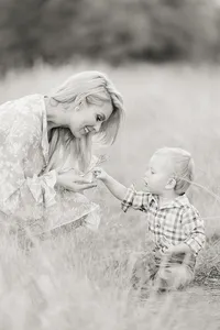 Black and white photo of a DFW mother holding a piece of grass her baby boy gave her.