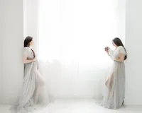 A before and after photo merged together of when the mother was still pregnant and wearing a grey tulle maternity gown holding her belly as shes standing in a Dallas/Fort Worth photography studio. On the other side is a photo of her holding her newborn baby while she is wearing the same tulle gown.
