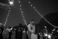 couple dancing under string lights and Zion cliffs