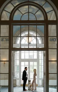 Couple standing together beneath elegant architectural arches during a Huntsville engagement session.