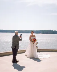 Bride posing by the lake with a colorful bouquet during her Huntsville wedding ceremony.