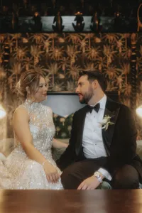 Bride and groom smiling at each other on bed