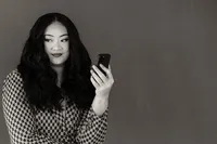 A woman holds her phone