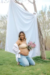 A pregnant woman is happy while holding her belly