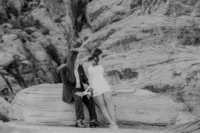 Engaged couple sitting on rock at the Red Rock Canyon smiling
