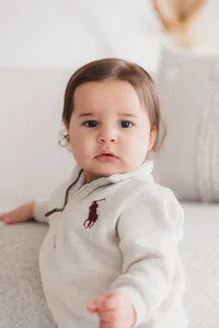 A baby boy looks at the camera.