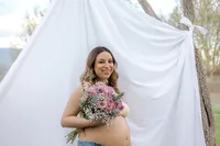 A woman smiles while holding flowers
