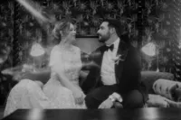 Bride and groom smiling at each other on bed
