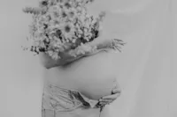 Close up of a pregnant belly and florals