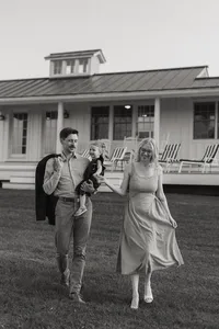 Jess and Corey Combs smiling holding their daughterin Manchester, Vermont