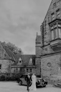 Bride and groom walking with castle in background in Ireland