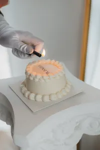 Someone lights a candle for a cake
