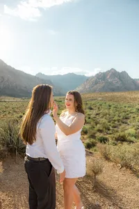 Woman wiping her fiance's lip with mountains in the back in Nevada