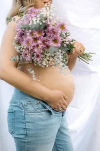 Close up of a pregnant belly with flowers