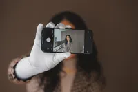 A woman takes a selfie with the phone pointed towards the viewer