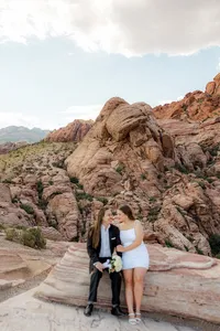 Engaged couple sitting on rock at the Red Rock Canyon smiling