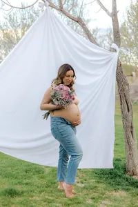 A woman holds her stomach while smiling