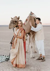 Bride and groom posing with a camel in cultural attire