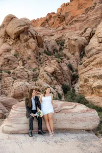 Engaged couple sitting on rock at the Red Rock Canyon smiling