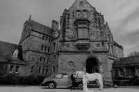 Bride and groom posing with horse and car in front of Ireland castle