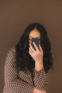 A woman leans into her phone
