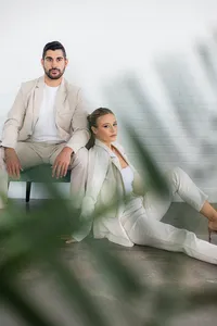 A couple poses in front of a brick wall