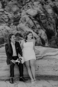 Engaged couple sitting on rock at the Red Rock Canyon smiling