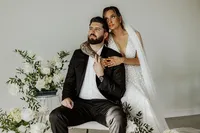 Bride and groom looking off into the distance with flowers to their left at The Landing Space