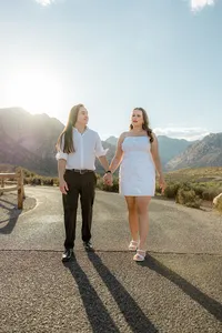 Engaged couple walking on empty road with Nevada mountains in the back