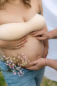 People hold a pregnant woman's belly