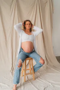 A woman poses on a stool
