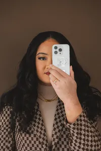 A woman holds a phone up to her eye