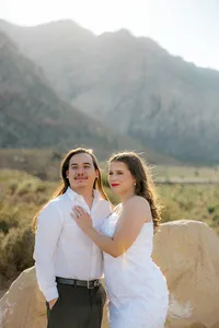 Engaged couples smiling with mountains in the background in Nevada
