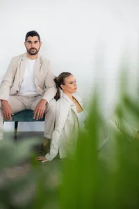 A couple poses in front of a brick wall