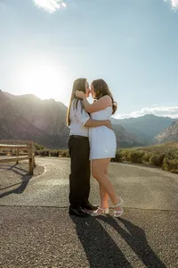 Engaged couple kissing on empty road with Nevada mountains in the back