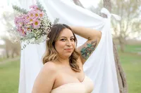 A woman poses with flowers behind her head