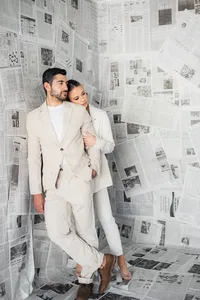 A couple hugs in front of newspapers