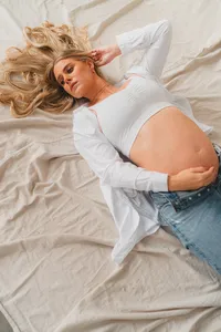 A pregnant woman lays on the ground