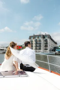 Bride and groom on boat looking off into distance