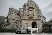 Bride and groom posing with horse and car in front of Ireland castle