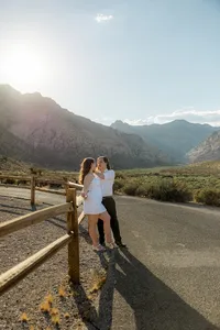 Engaged couple leaning up against fence with Nevada mountains in the back