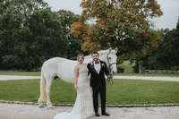 Bride and groom in front of a white horse for their Ireland wedding